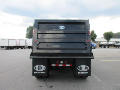 Dump truck bed of a new Western Star 47X with TEBD stickers on mud flaps and rear view showing tailgate.