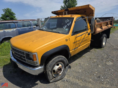 1980s-1990s Chevrolet C/K 3500 series dump truck side view showing orange cab and open dump bed with black wheels