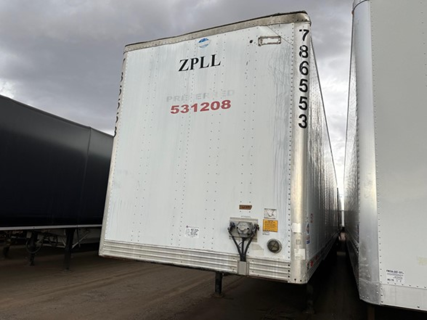 Rear view of a white Utility 4000D-X trailer with ZPLL markings, stock number UE11183, and serial digits along the right edge.