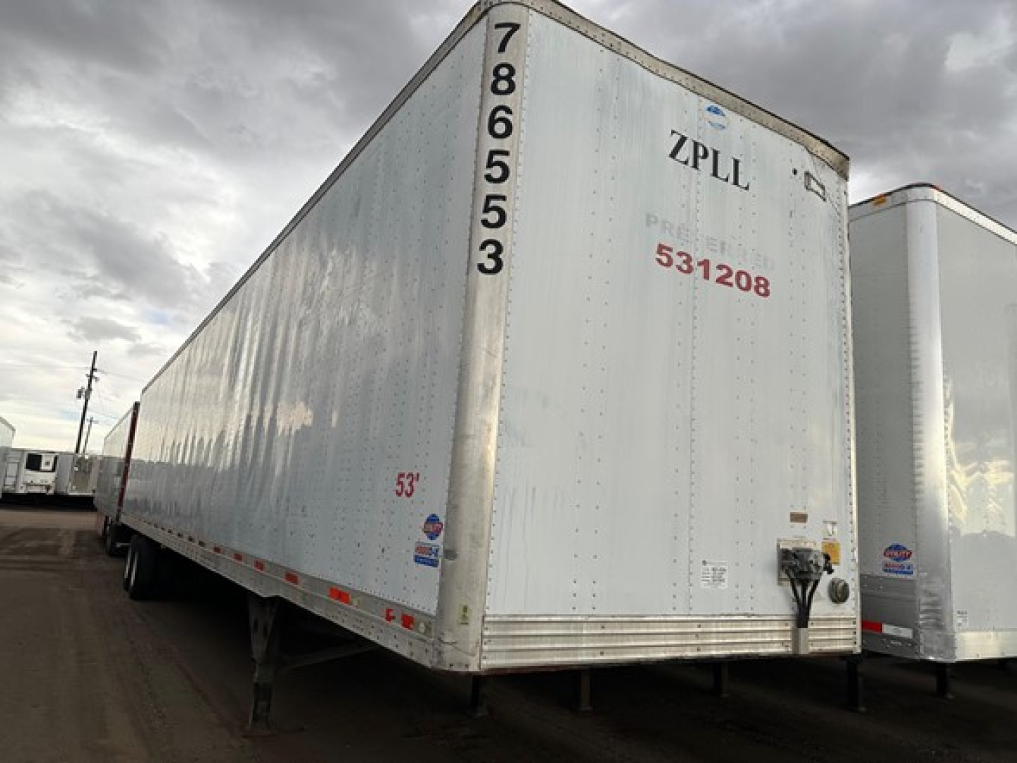 Trailer side and rear of a white 53' utility trailer with vertical numbers 786553 along edge, ZPLL on rear, red ID 531208, and a blue logo near bottom.