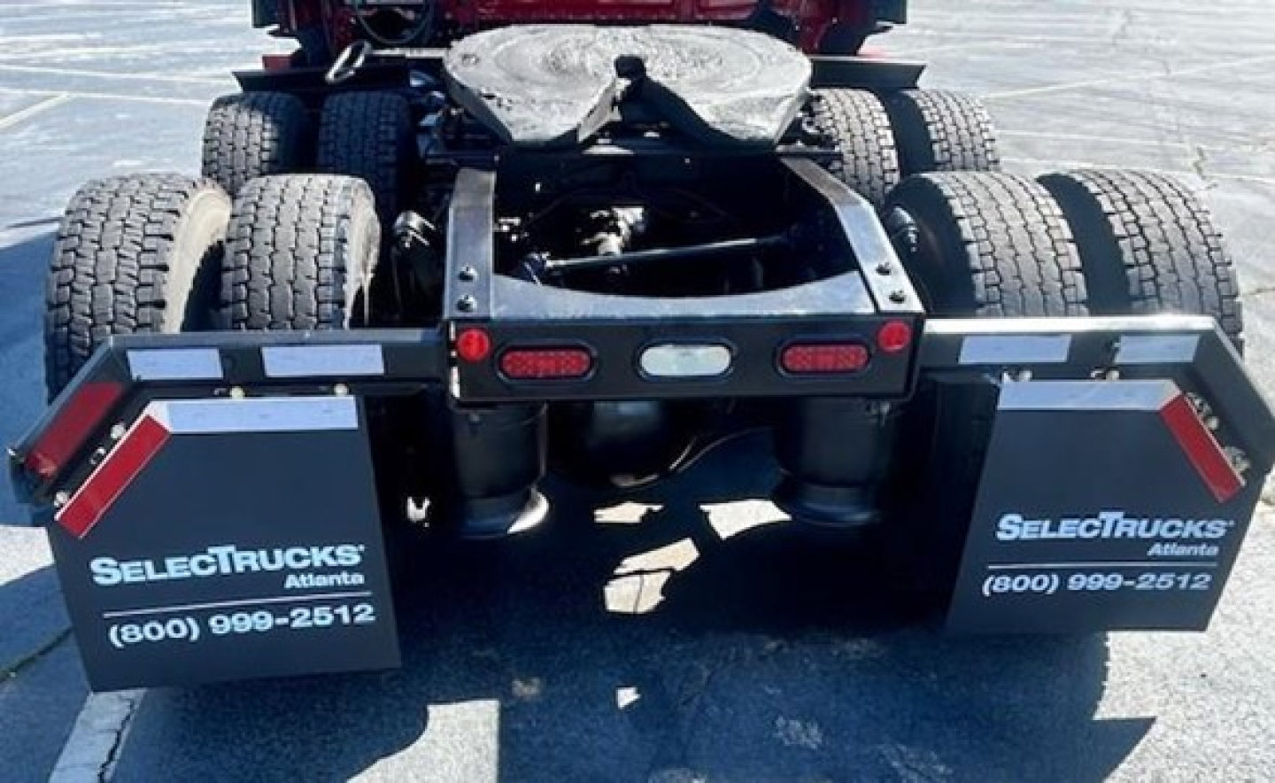 Rear view of a 2023 Freightliner Cascadia 126 truck chassis showing dual rear axles and mud flaps with SelectTrucks branding.