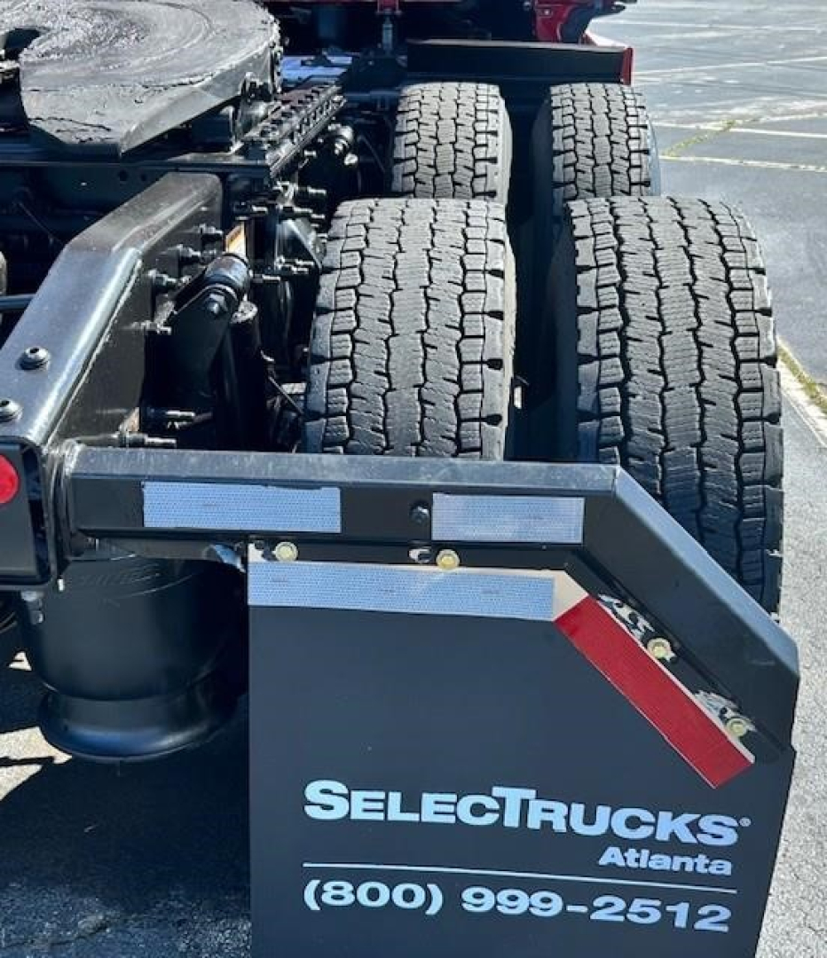 Rear view of a Freightliner Cascadia truck chassis showing dual rear axles and a SelectTrucks Atlanta plate with contact number.