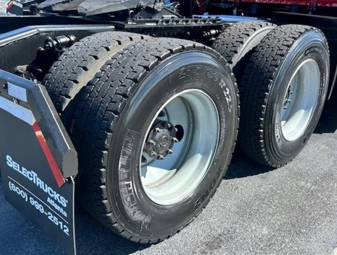 Dual rear truck wheels with tires and rims on a Freightliner Cascadia chassis viewed from side.