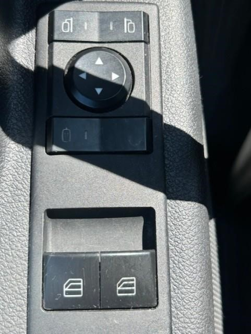 Freightliner Cascadia interior controls with window/lock switch panel and mirror adjustment knob visible