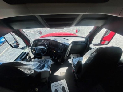 Cab interior of a Freightliner Cascadia 126 truck showing driver and passenger seats with protective covers and dashboard.