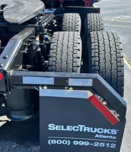 Rear view of a Freightliner Cascadia truck chassis showing dual rear axles and a SelectTrucks Atlanta plate with contact number.