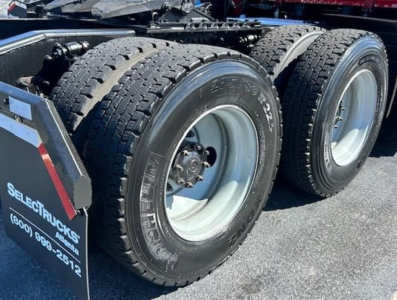 Dual rear truck wheels with tires and rims on a Freightliner Cascadia chassis viewed from side.