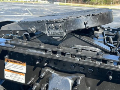 Front view of Freightliner Cascadia cab-over hitch assembly and chassis with warning label plate and hitch components visible