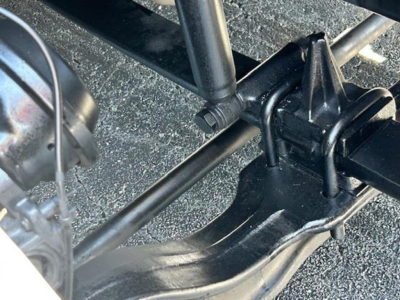 Truck chassis view showing suspension linkage and mounting bracket of Freightliner Cascadia undercarriage.