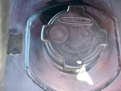 Freightliner fuel cap on diesel tank with 'Diesel Only Push and Turn' label and security ring visible.