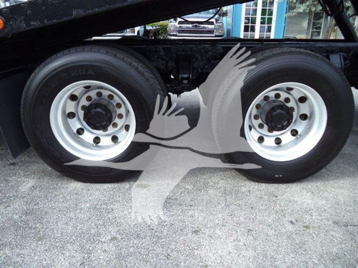 Dual rear axles of a Peterbilt truck chassis with silver rims and black tires; no visible model text.
