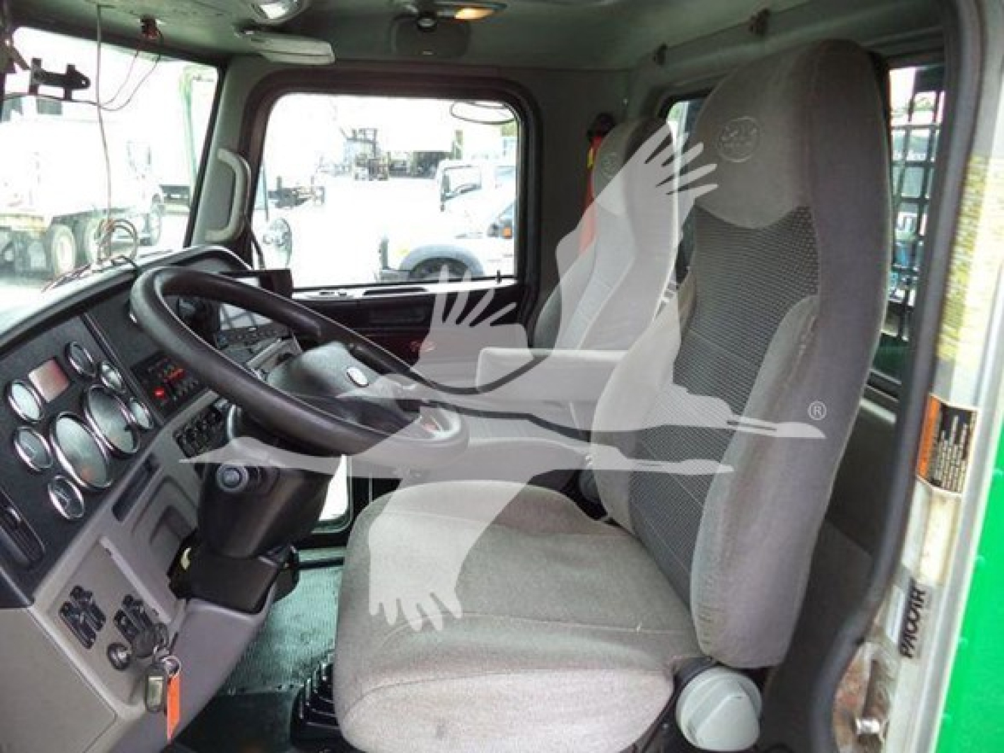 Truck cab interior of a 2014 Peterbilt 367 showing driver seat, steering wheel, and dashboard gauges from the passenger side.