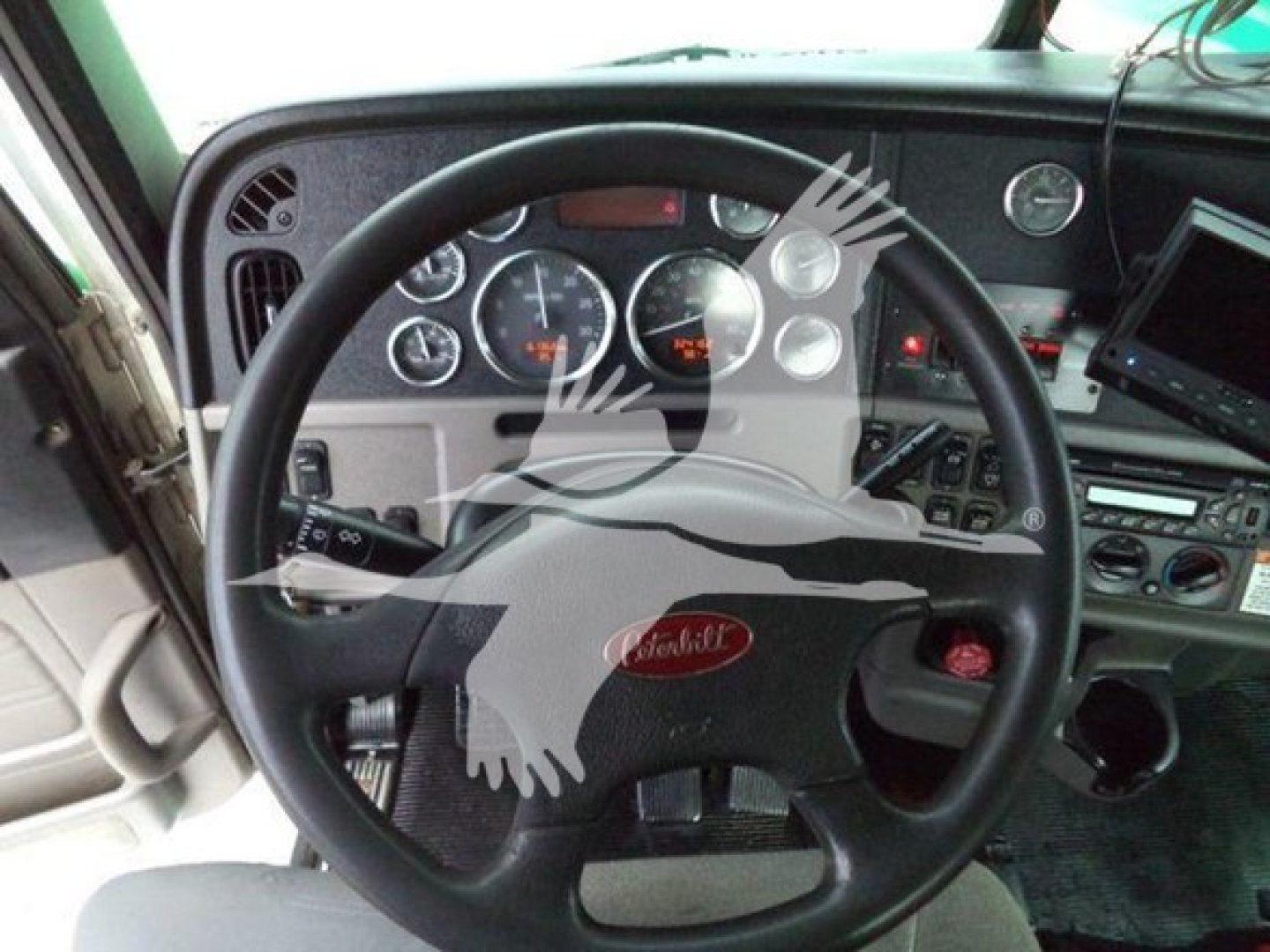 Peterbilt dashboard and steering wheel interior showing gauges and controls.