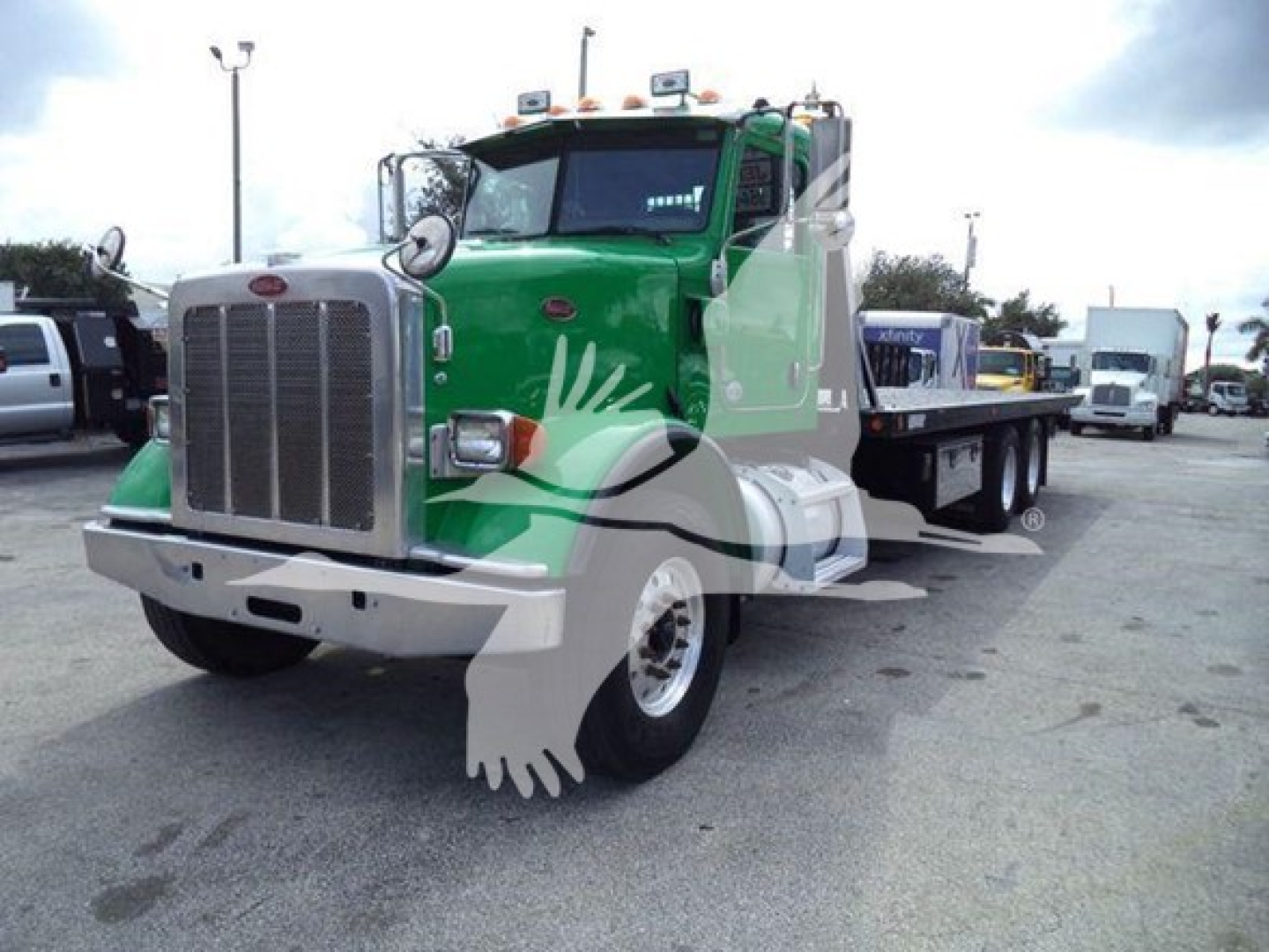 Peterbilt 367 rollback truck showing front view and green cab with chrome grille and bumper.