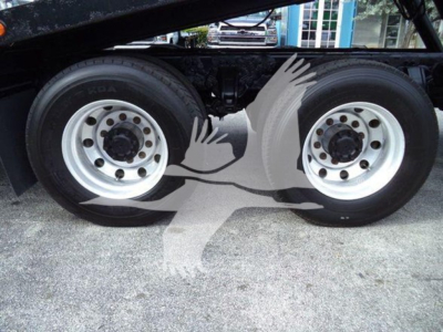 Dual rear axles of a Peterbilt truck chassis with silver rims and black tires; no visible model text.