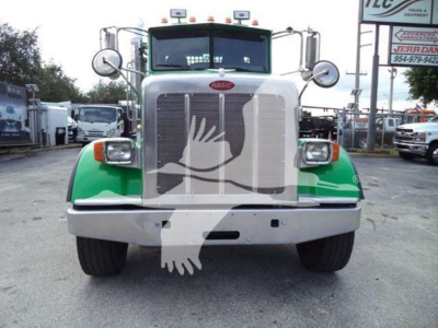Front view of a green and silver Peterbilt 367 rollback truck with large grille, bumper, round mirrors, and headlights.