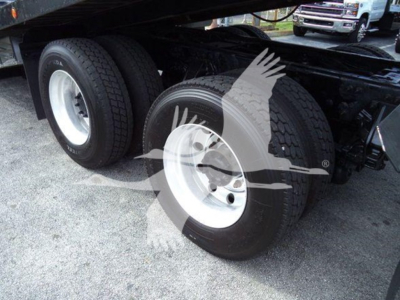 Truck rear wheels and suspension of a Peterbilt truck with dual tires and white rims. No visible text readable on tires or components.