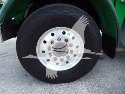 Truck wheel and tire assembly on a Peterbilt 367 rollback showing steel wheel with multiple lug holes and a large tire labeled Goodyear.
