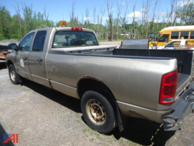 Pickup truck bed view of a 2004 Dodge Ram 1500 with extended cab, showing rust along lower body and pickup bed, rear taillight and wheel.