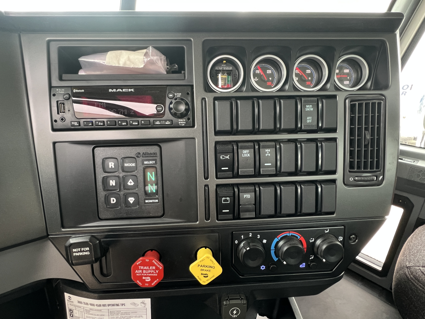 Dashboard of a 2027 Mack GR64B rolloff truck showing gauges, switches, and controls in the instrument panel.