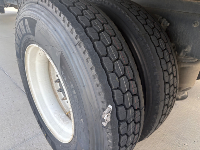 Duplex rear wheels of a Freightliner M2-106 truck showing dual tires and wheel rims; clear tread pattern visible.