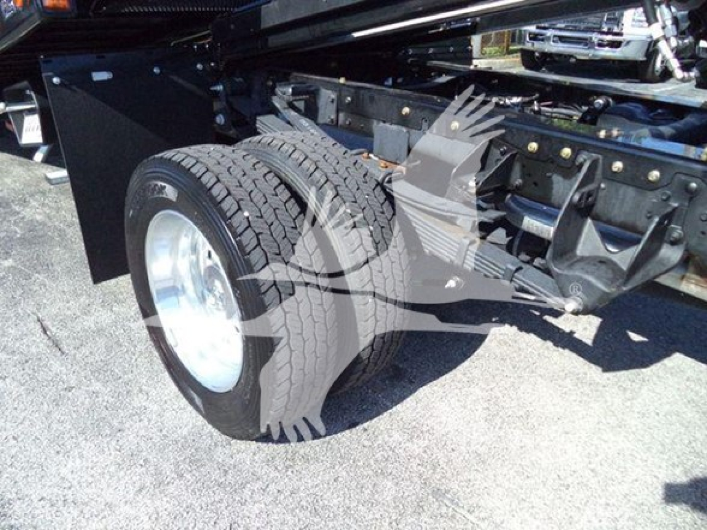 Truck rear wheel and chassis showing dual rear tires and metal frame components.