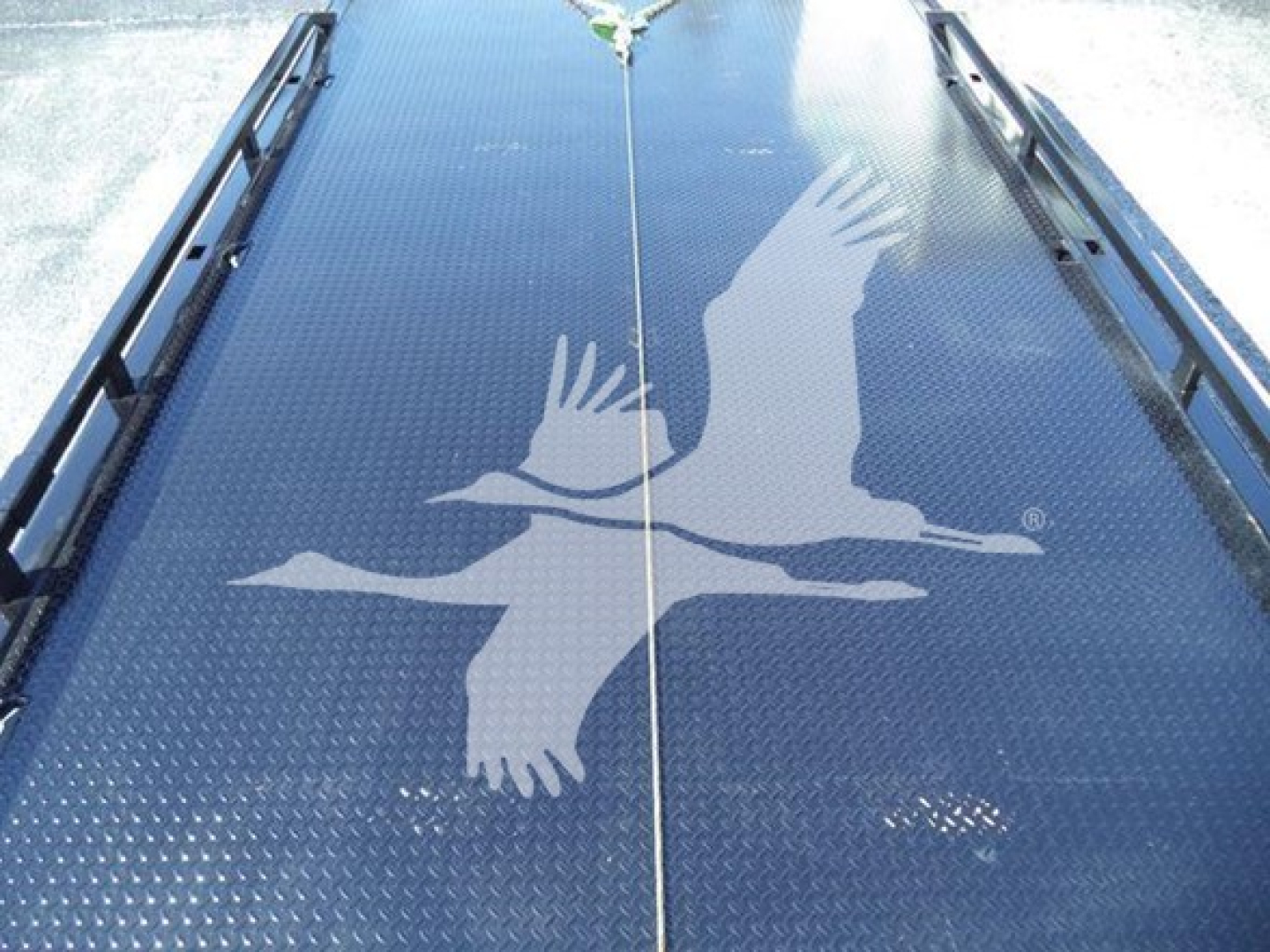 Ram 5500 rollback truck bed with diamond plate and a graphic of birds in flight on the bed surface.