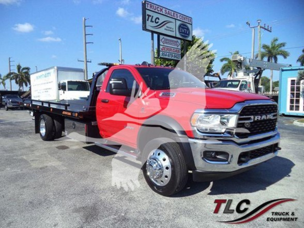 Ram 5500 SLT rollback tow truck front and side view showing extended flatbed and dual rear wheels with chrome rims.