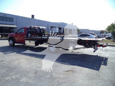 RAM 5500 pickup with rollback equipment in view; truck shows external text: none clearly legible due to overlay. The image mainly displays a red Ram 5500 with a rollback bed and a flatbed mechanism.