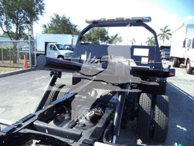 Ram 5500 rollback truck chassis with dual rear wheels and tow hitch, rear view showing roll-back bed and cab; no visible text.