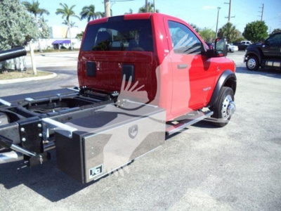 Ram 5500 rollback truck side view showing aluminum toolbox and chassis with cab in red, SLT trim, VIN label not visible.