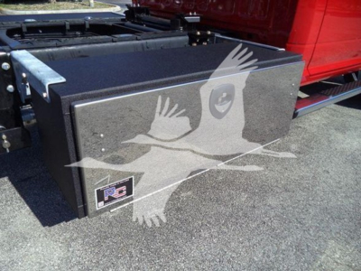 Ram 5500 rollback truck with a black toolbox mounted on side of bed; visible sticker with RC logo and a white ghost-like illustration overlay.
