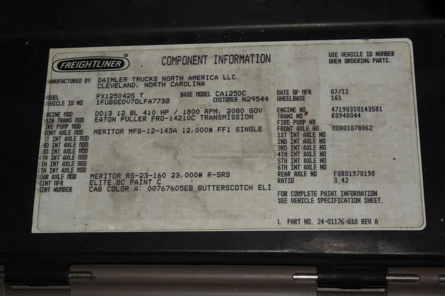Freightliner component information placard in engine bay showing model CASCADIA 125 information including VIN, stock, and engine/transmission details.
