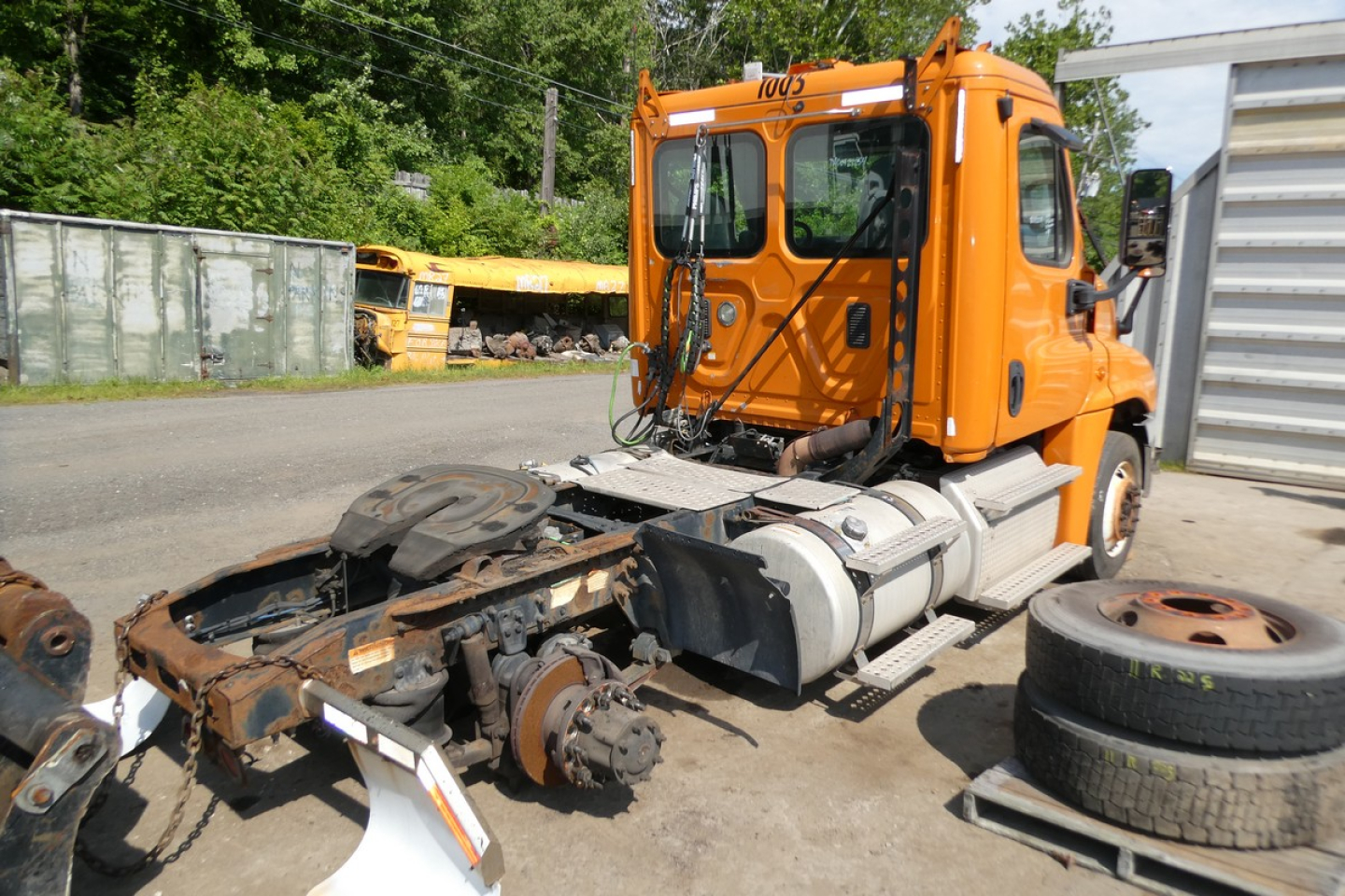 Truck cab showing front half of a Freightliner Cascadia 125 replaced with missing chassis and exposed drivetrain components.