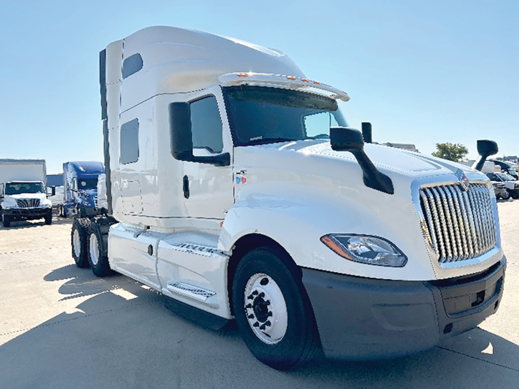 Truck cab in-service showing International LT625 sleeper tractor with white paint and grille, front view, daytime.