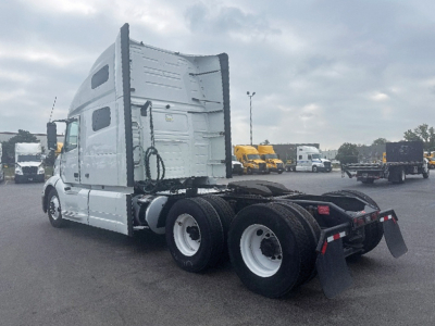 Volvo VNL 760 truck in a yard showing side view with sleeper cab and dual rear axles; wheel wells and mudflaps visible.