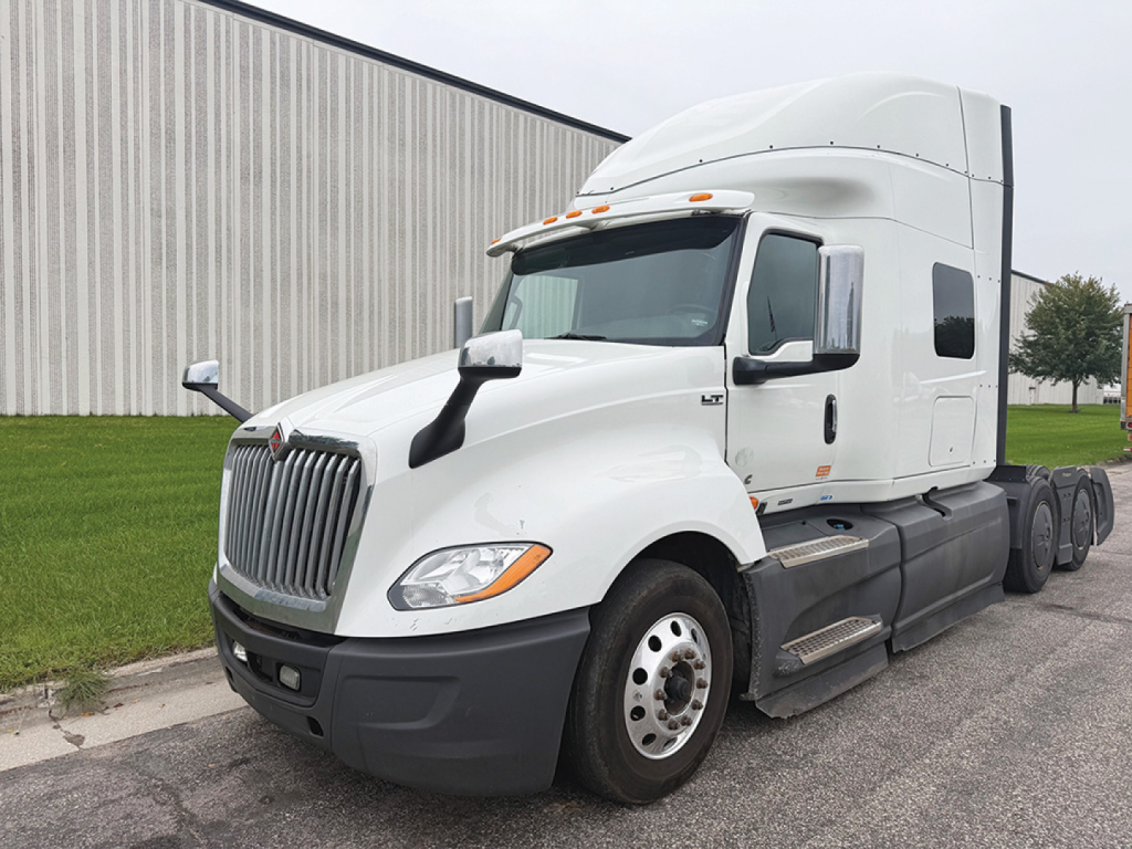 International LT625 sleeper tractor in white, side view showing cab, grille, headlights, and dual rear axles.