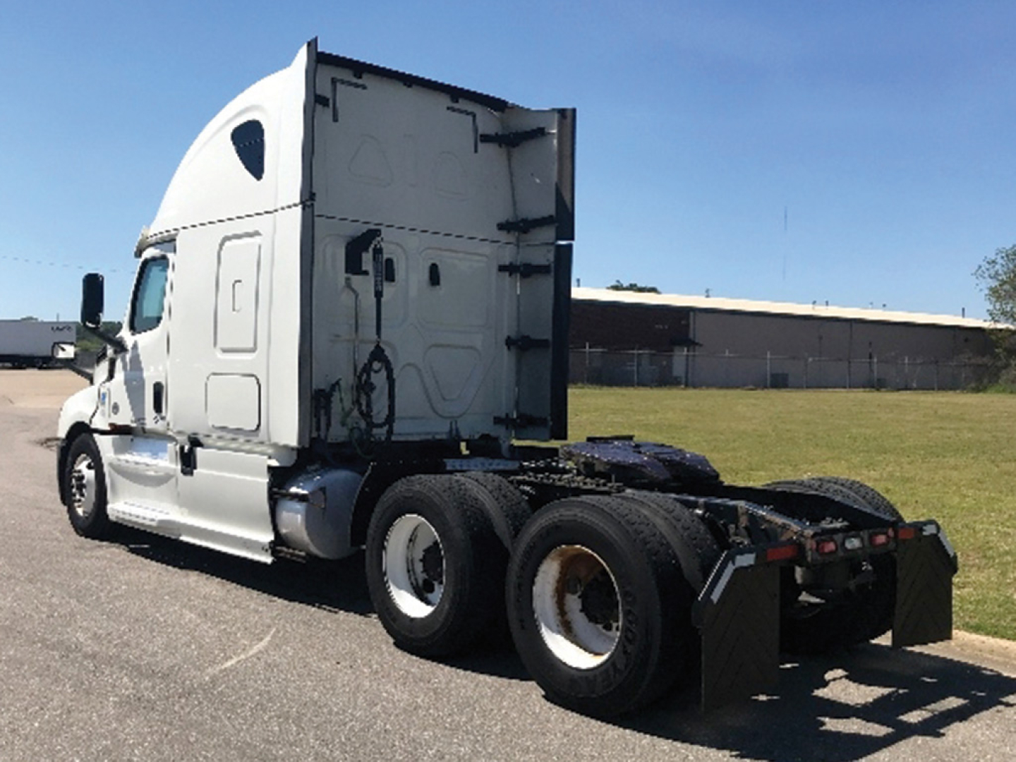 Truck side view of a 2018 Freightliner Cascadia126 sleeper cab tractor showing rear wheels and chassis.