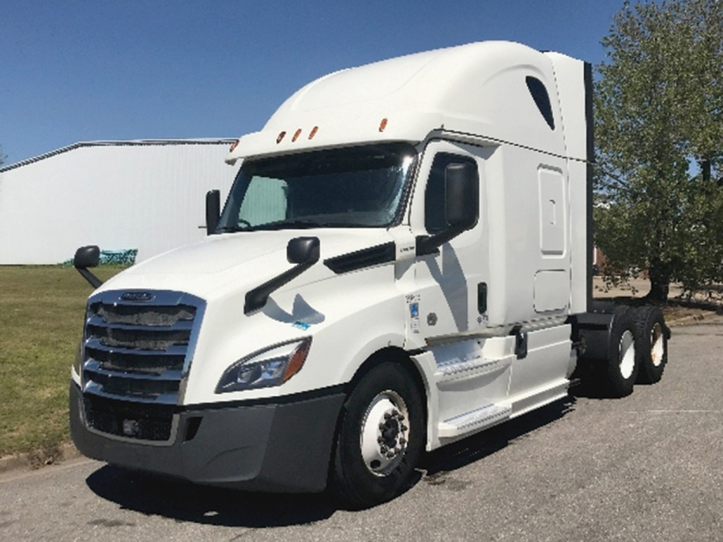 Truck cab of a white 2018 Freightliner Cascadia126 Conventional Sleeper showing side mirror, grille, and front wheel.