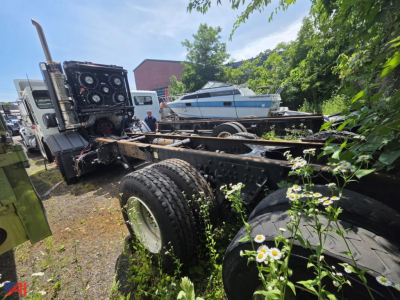 Cab and chassis truck frame with large dual rear wheels and crane control panel visible in rear, Toyota crane carrier LET2-46 identifying components