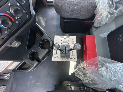 Mack GR64B rollover control panel with switches and dials visible in cab interior