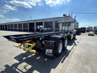Mack GR64B roll-off truck chassis and rear view showing hydraulic trailer hitch and BTE branding on mudflaps.