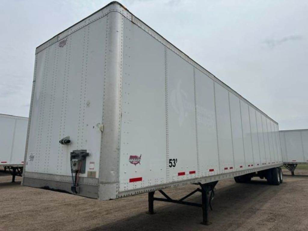 Trailer side view showing a 53' aluminum box trailer with front corner, hitch, and support legs; visible markings include 53' length and warning decals.