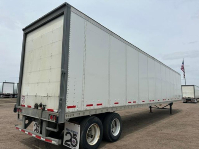 2016 Wabash van trailer showing side panels, rear doors, and dual axle with tires. Visible labels include small red and white reflective markings along the lower edge and rear with a number plate and trailer frame.