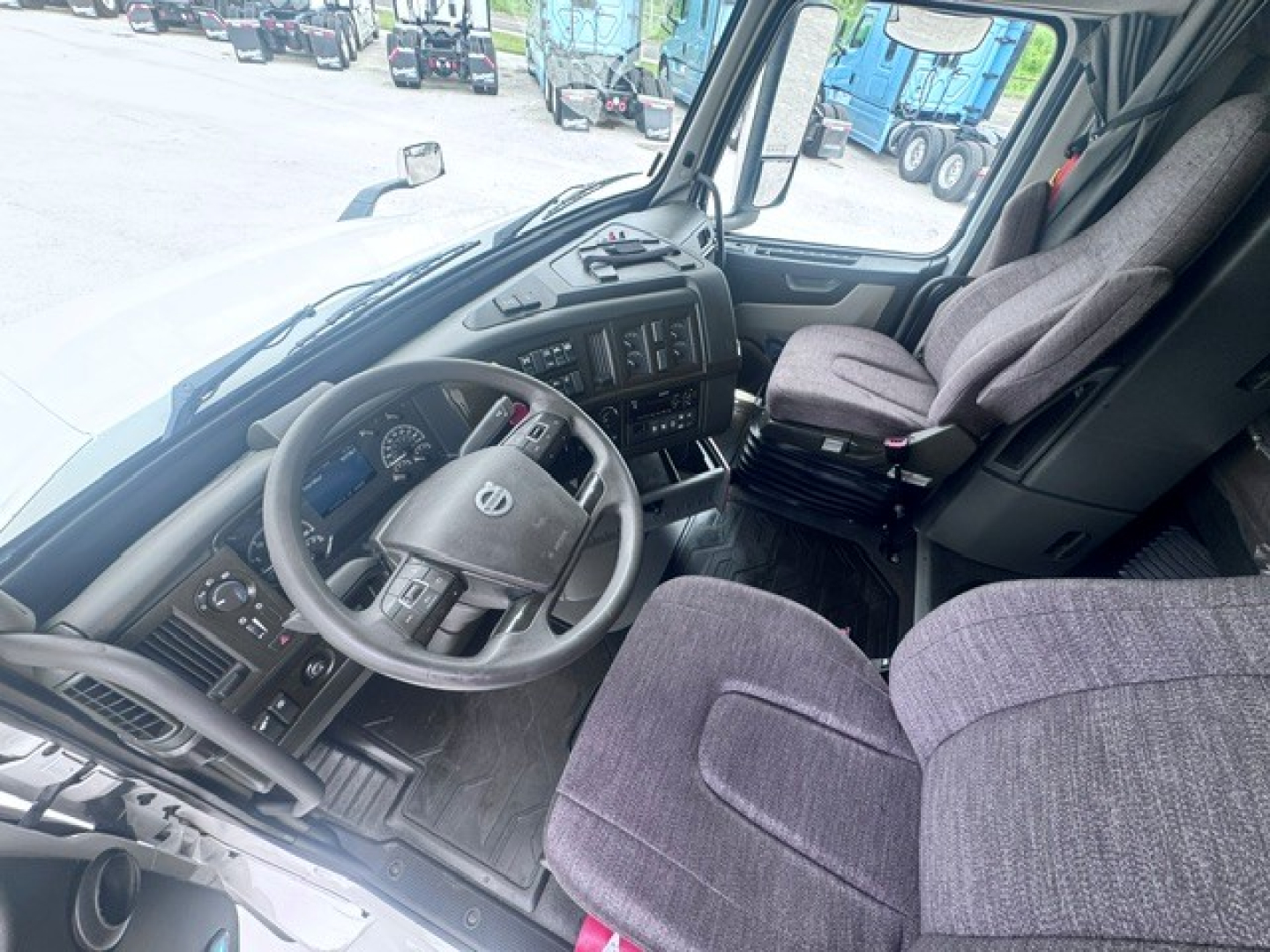 Volvo VNL64T740 interior cab view showing steering wheel dashboard and driver's seat.