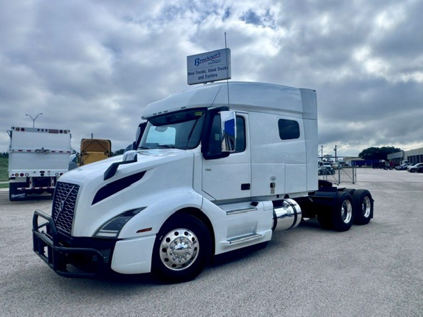 Volvo VNL64T740 tractor unit in white, side view showing cab, dual rear axles, and fuel tanks.