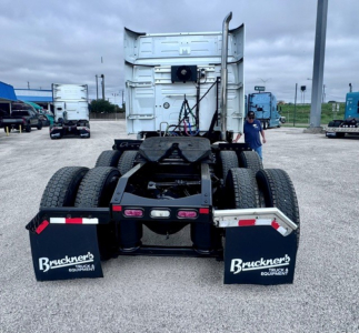 Rear view of a Volvo VNL64T740 truck tractor chassis showing dual rear axles and mud flaps with Bruckner's Truck Equipment logos.