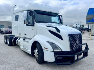 Volvo VNL64T740 tractor-trailer cab in white with black grille guard; front view showing grille, headlights, and side mirrors.