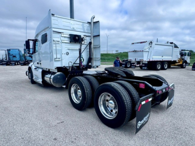 Volvo VNL64T740 tractor truck rear and side view with dual rear axles and fifth wheel, exhaust stack, and fuel tanks visible.