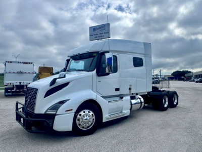 Volvo VNL64T740 tractor unit in white, side view showing cab, dual rear axles, and fuel tanks.